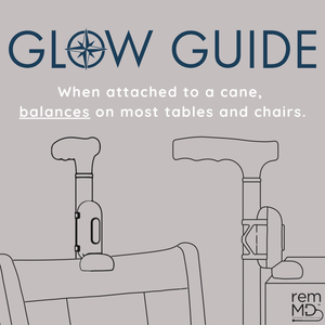 Illustration of a cane with a 'Glow Guide' feature attached, balancing on a chair.